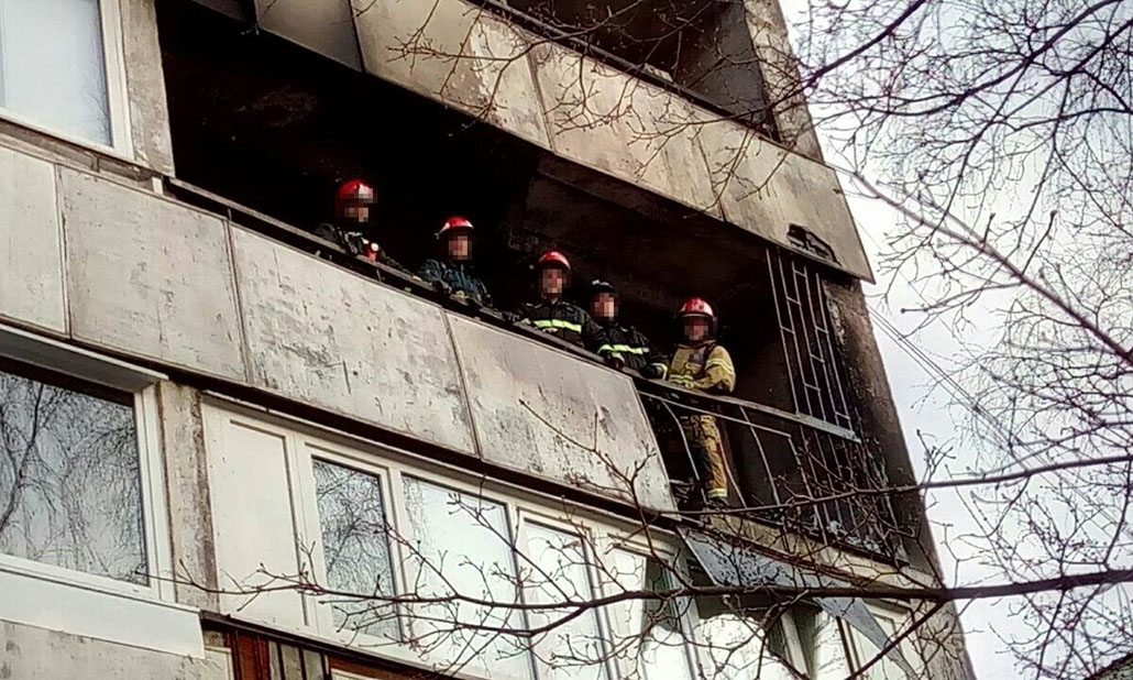 Пожарные на балконе многоэтажного дома после тушения